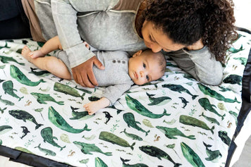 Baby on Board! Top Tips to Pamper the New Mom in Your Life: mother and baby on a whale-themed blanket.