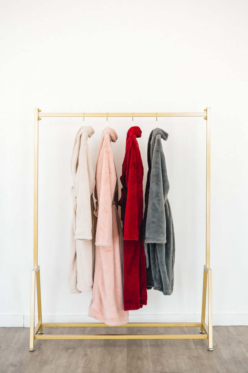 12 Minky Couture Gifts To Get Your Significant Other This Holiday Season - Cozy robes in various colors hanging on a rack.