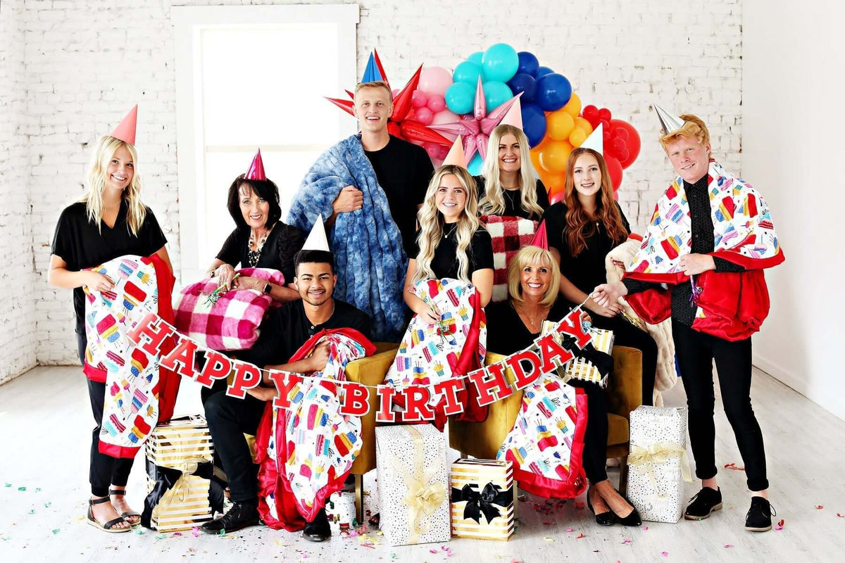 We're TWELVE!! birthday celebration with party hats, new blankets, and joyful team members.