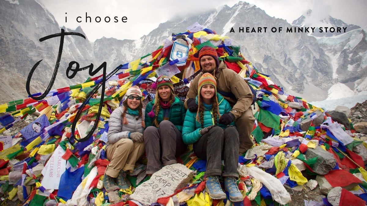 Heart of Minky Story, I Choose Joy: Elise and friends celebrate atop colorful prayer flags at Everest.