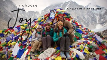 Heart of Minky Story, I Choose Joy: Elise and friends celebrate atop colorful prayer flags at Everest.