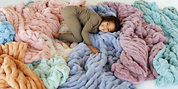 Child enjoying cozy blankets in pastel colors, perfect for Fall Recipes We Love and holiday cooking.