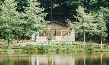Style Steal: The Practical Guide to Decorating Your Log Cabin Interior - serene log cabin by a lake surrounded by trees