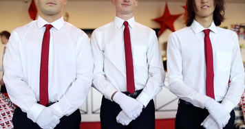 Three individuals in white dress shirts and red ties standing together, ready for Minky Couture's White Glove Sale event.