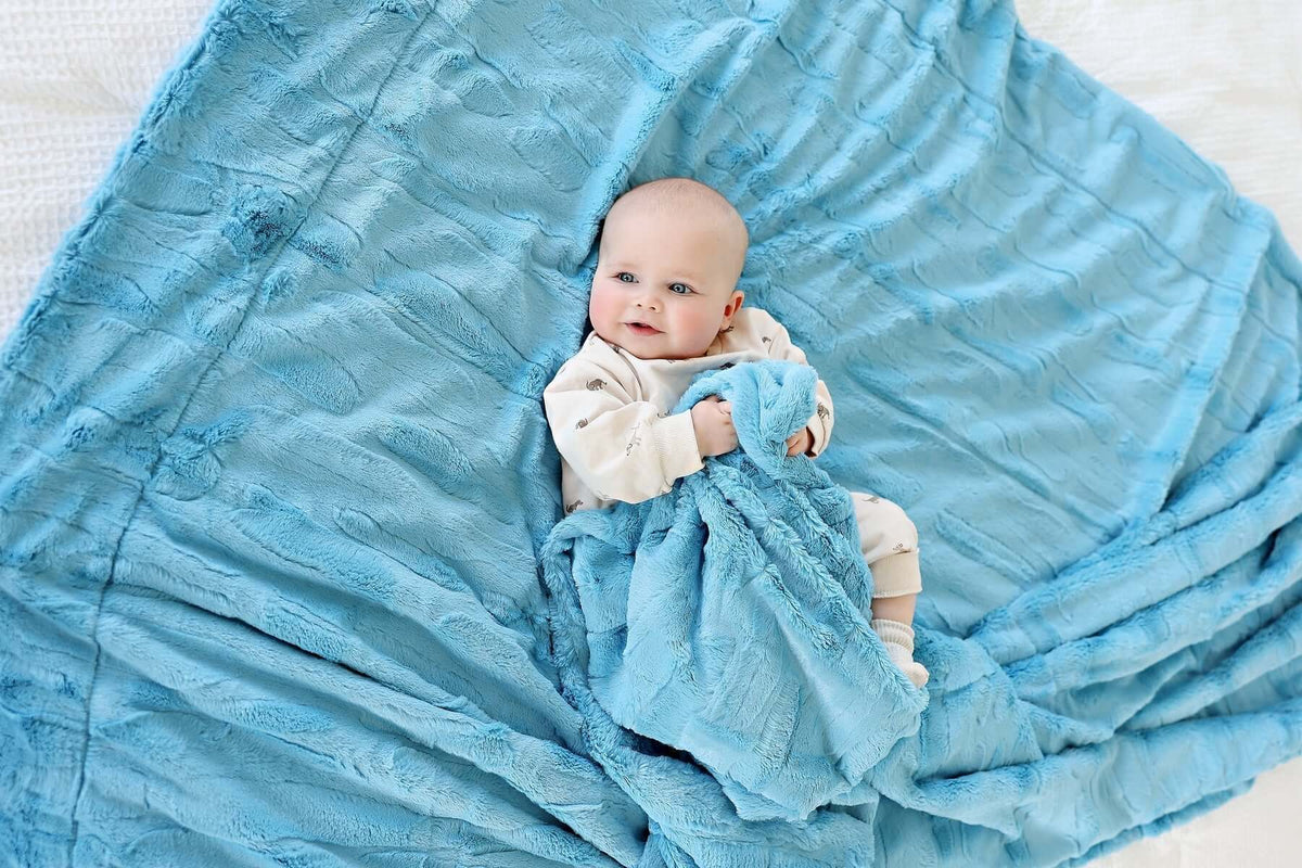 25 Thoughtful Baby Shower Gift Ideas That New Parents Will Actually Love and Use - Baby with soft blue blanket.