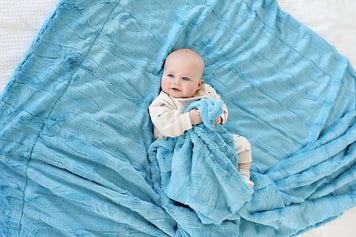 25 Thoughtful Baby Shower Gift Ideas That New Parents Will Actually Love and Use - Baby with soft blue blanket.