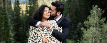 Honeymoon Packing List: Essentials for Every Destination couple cuddling in nature with a cozy blanket.