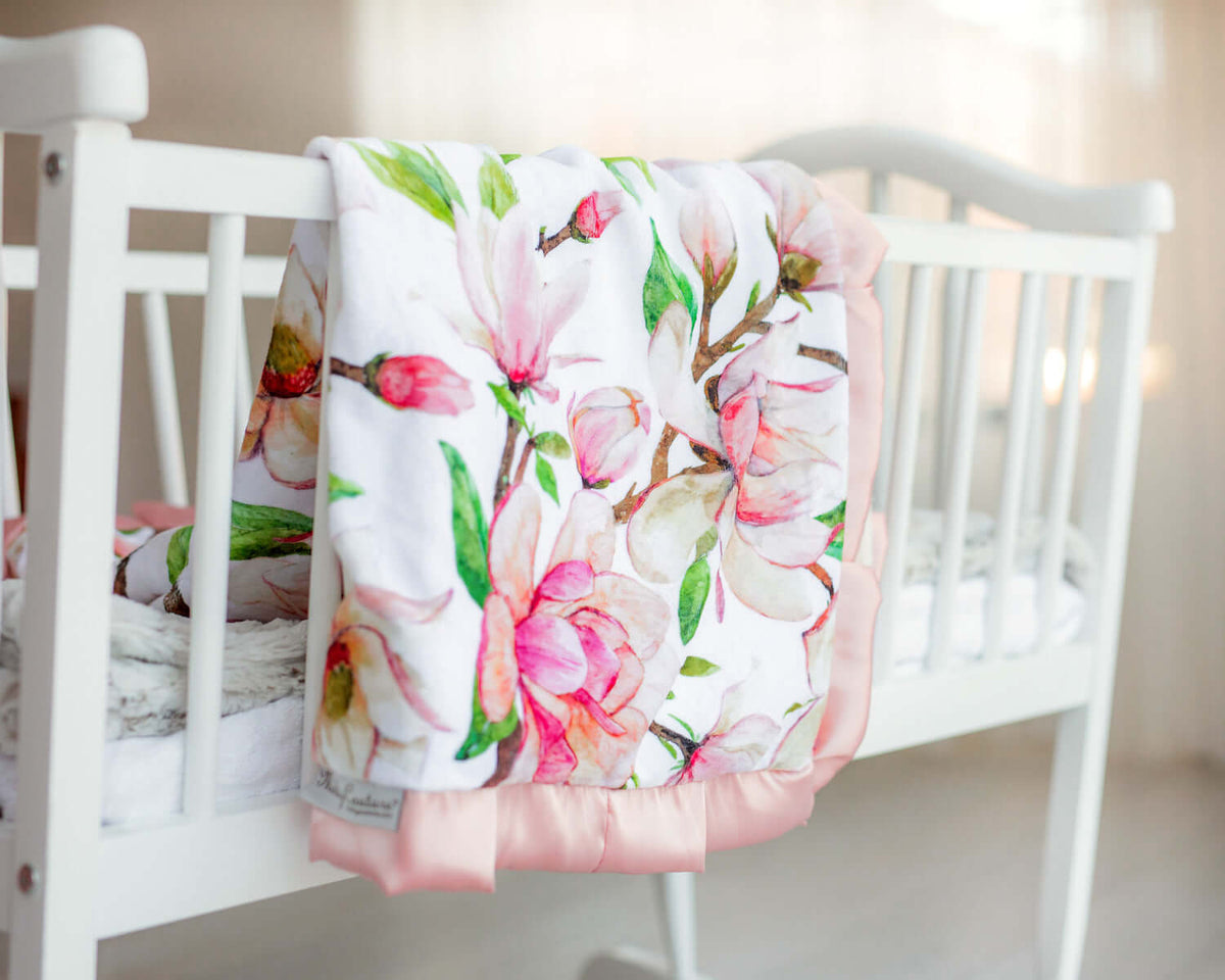 Colorful floral blanket draped over a crib, perfect for the transition to a bed.