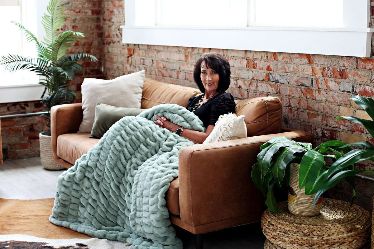Interior Décor Ideas to Banish the Winter Blues with a cozy sofa and warm blanket in a stylish living room.