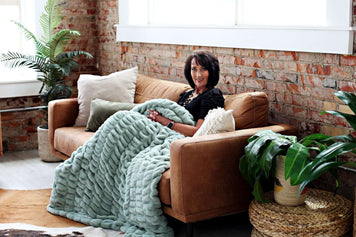 Interior Décor Ideas to Banish the Winter Blues with a cozy sofa and warm blanket in a stylish living room.