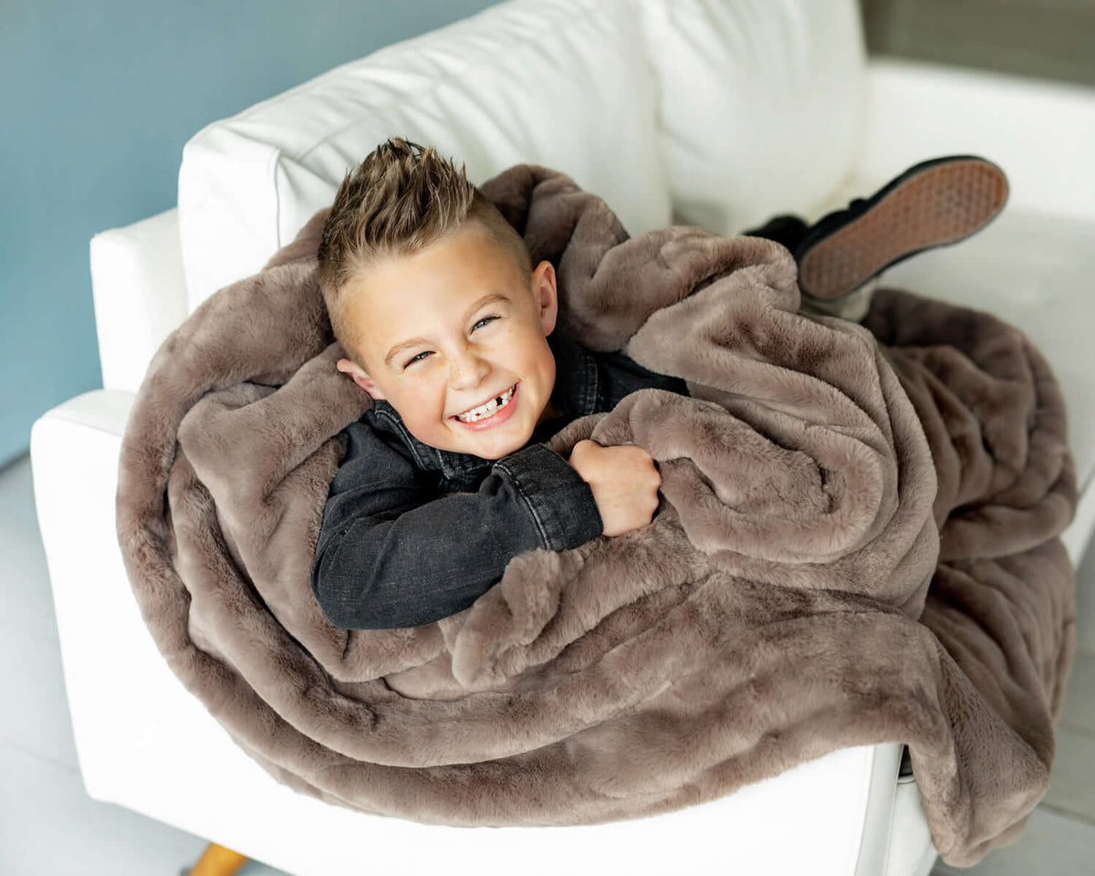 Child snuggled in a cozy blanket, enjoying a fun and relaxed atmosphere for Ideas for an Ultimate Kids Movie Night.