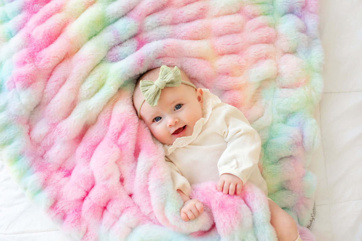 Must-Have Baby Nursery Essentials: A Complete Checklist with a smiling baby on a colorful blanket.