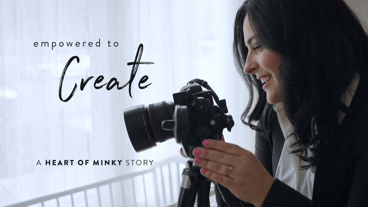 A woman joyfully holding a camera with the text 'empowered to Create' and 'A HEART OF MINKY STORY'.