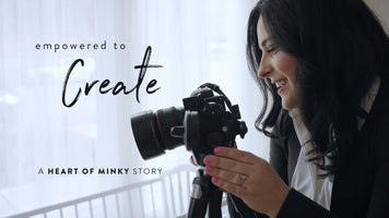 A woman joyfully holding a camera with the text 'empowered to Create' and 'A HEART OF MINKY STORY'.