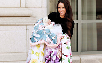 A woman holds floral blankets from Our Hope Collection while cradling a baby, showcasing new designs for 2021.