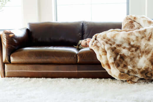 Blanket Folding Techniques: Creative Ways to Store and Style Your Blankets on a cozy sofa with a person relaxing.