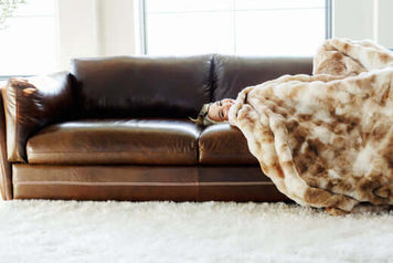 Blanket Folding Techniques: Creative Ways to Store and Style Your Blankets on a cozy sofa with a person relaxing.