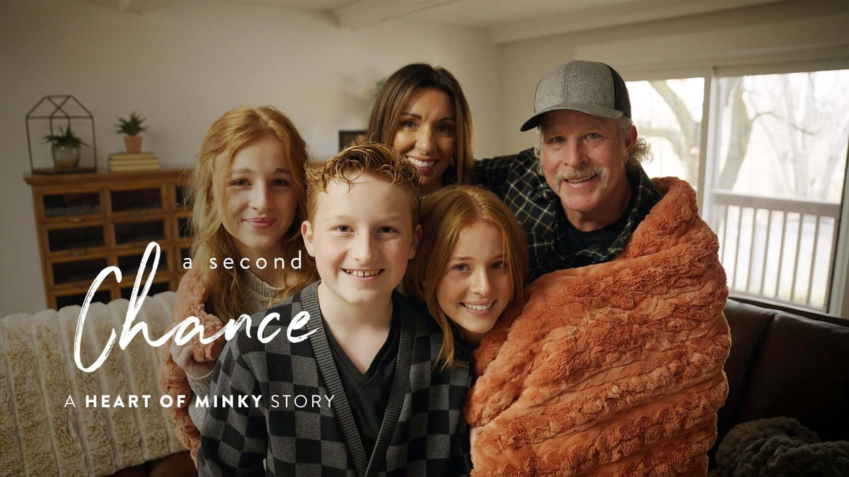 A family smiling together wrapped in a blanket, representing a Heart of Minky Story - A Second Chance.