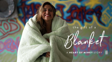 Woman smiling while wrapped in a soft blanket, representing the Heart of Minky Story - The Gift of a Blanket