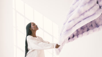 Woman holding a weighted blanket while learning how to wash a weighted blanket at home.