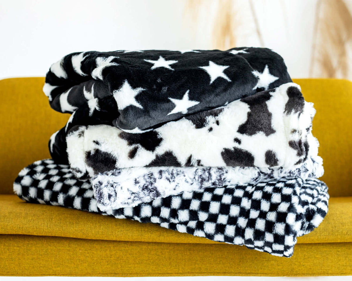 Storage Ideas for Blankets: cozy Minky blankets stacked on a couch for stylish blanket organization.