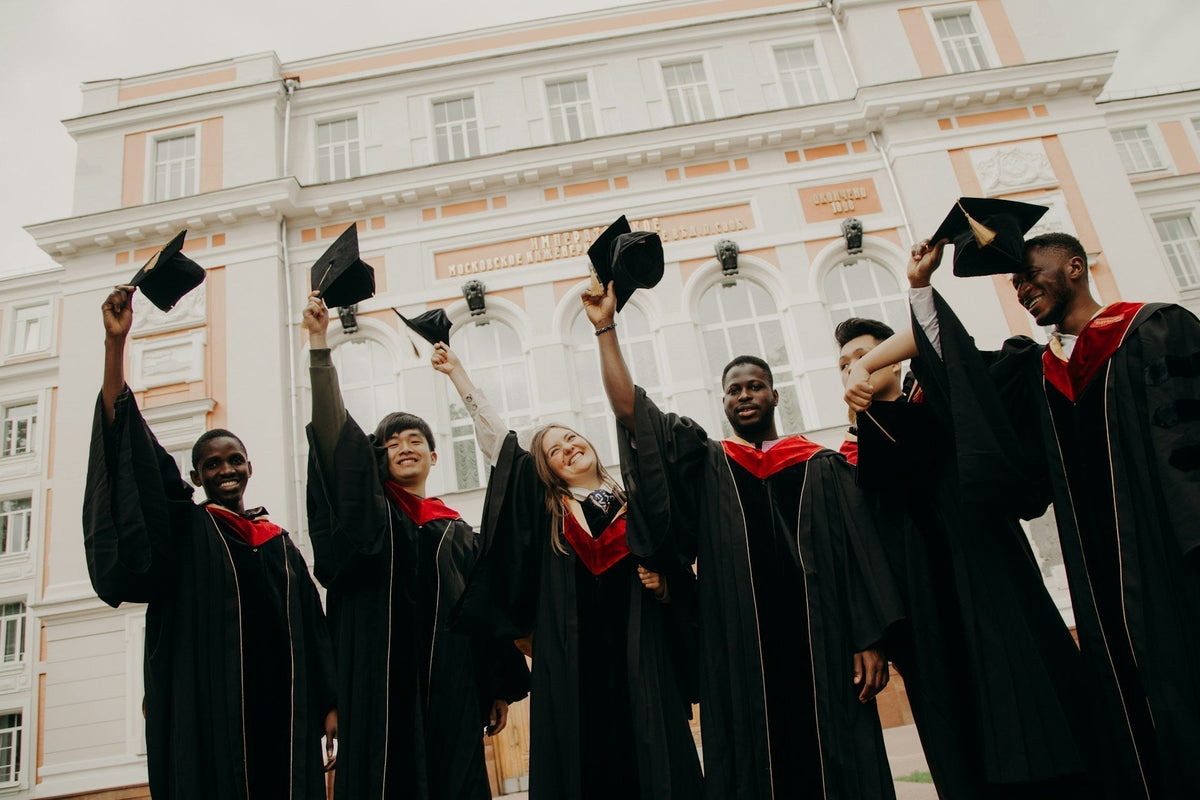 Graduates celebrating with caps in hand, showcasing joy for 19 Graduation Gift Ideas.