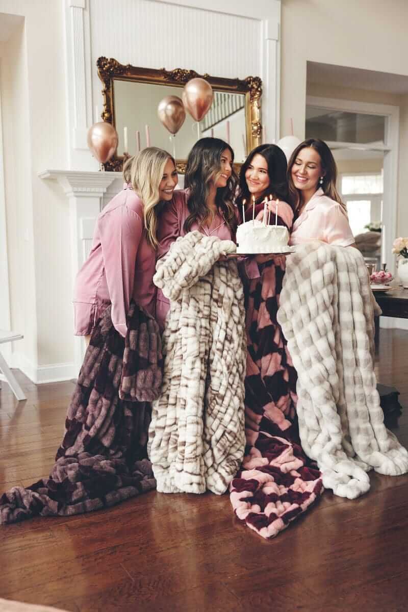 Four women celebrating together, wrapped in plush Minky Couture blankets.