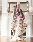 Woman posing with a faux fur Minky Couture Hugs Kaci Chocolate Marble blanket.