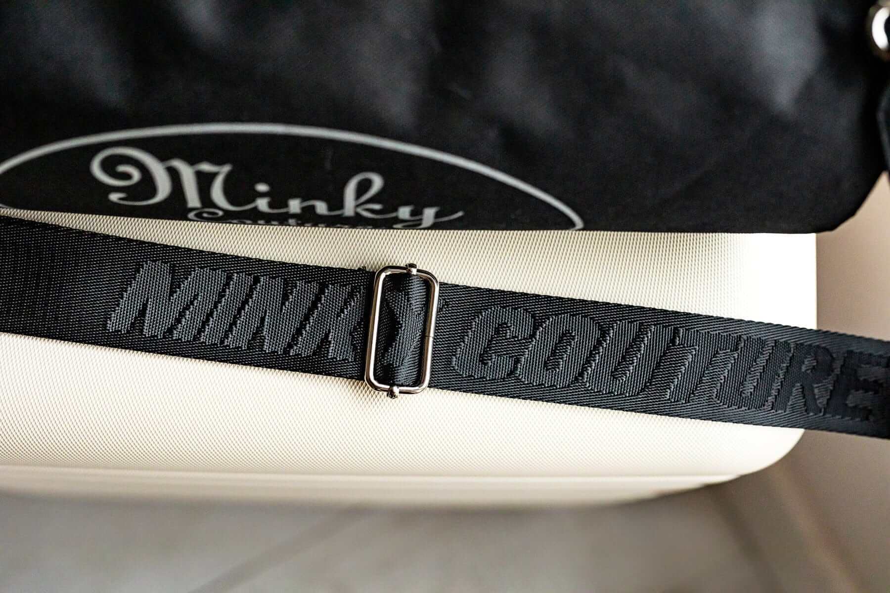 Carrying strap of a Minky Couture blanket travel bag, embossed with the words 