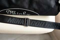 Carrying strap of a Minky Couture blanket travel bag, embossed with the words "Minky Couture"