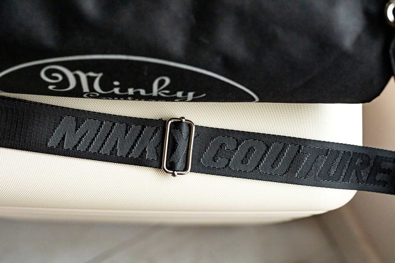 Carrying strap of a Minky Couture blanket travel bag, embossed with the words "Minky Couture"