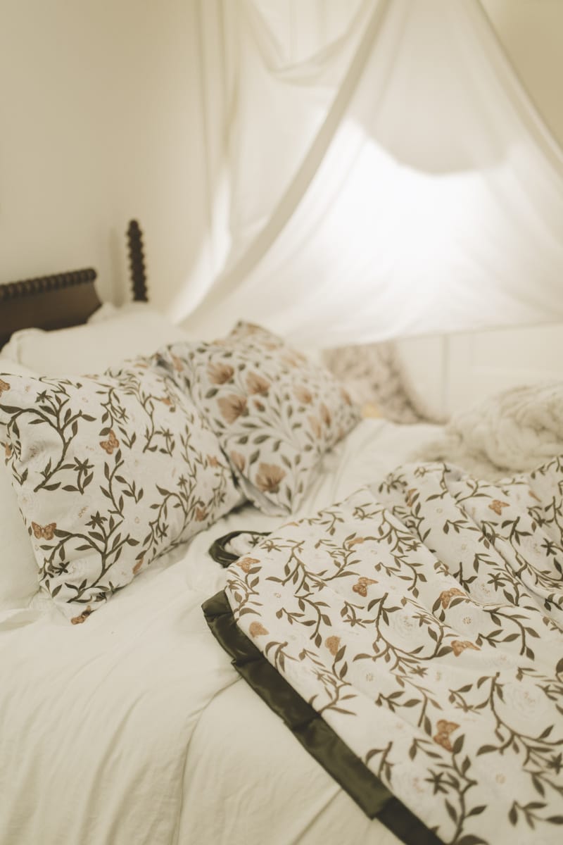 Peony Garden floral-patterned bedding on a bed with a canopy.