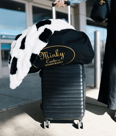 Travel Bag with a Minky blanket on top of a suitcase ready for travel at an airport.