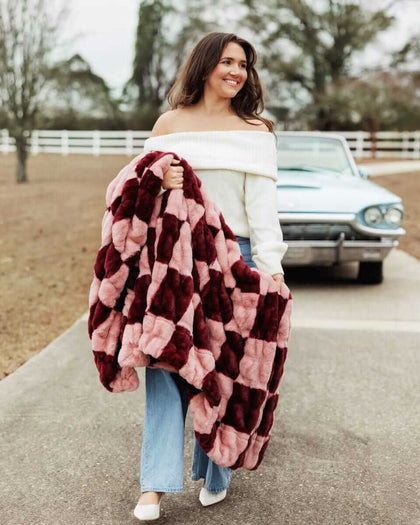 Woman walking with a plush Minky Couture Hugs Devin Pink Checkered blanket.