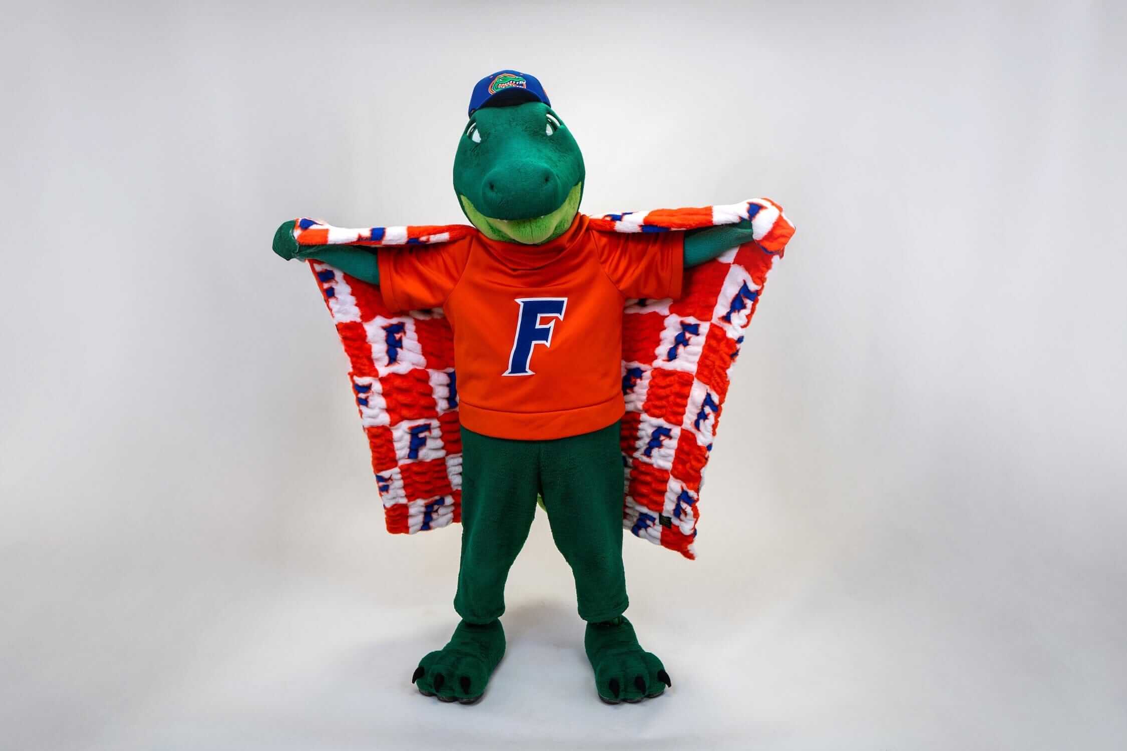 Florida Gators Blanket draped over the Florida Gators mascot in an orange shirt with checkered pattern background.