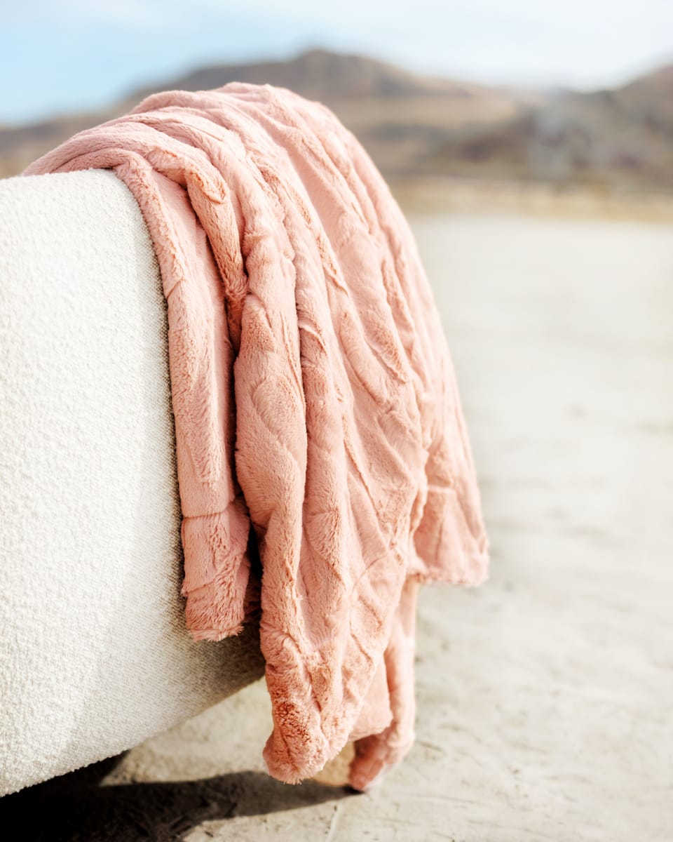 Soft and cozy Sorbet Apricot Vanilla Blanket draped over a modern sofa, perfect for adding warmth and style.