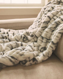 Close-up of a plush Minky Couture blanket draped over a sofa, showcasing its thick, ultra-soft texture and cozy folds.