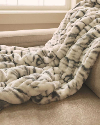 Close-up of a plush Minky Couture blanket draped over a sofa, showcasing its thick, ultra-soft texture and cozy folds.