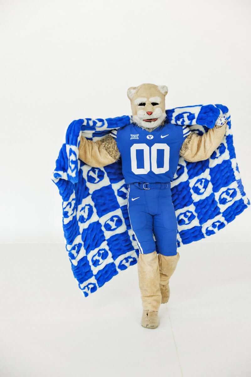 Minky Couture BYU Cougars Blanket being showcased by a mascot in a blue jersey with a checkered design.