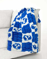 Minky Couture BYU Cougars Blanket draped over a couch, featuring a blue and white checkered design with the BYU logo.