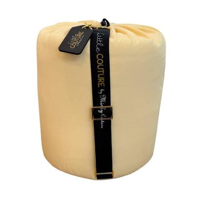 Butter yellow baby sleeping bag rolled with black Little Couture strap and gold hardware.