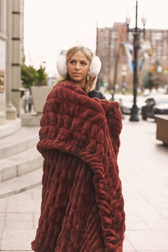 Person wrapped in a large warm brown Hugs Rich Mahogany Blanket on a city street Soft blanket Minky Couture.