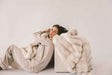 Model lounging with the luxurious Extreme Ultra Cloud Ancient Scroll Blanket, showcasing its softness and elegance.