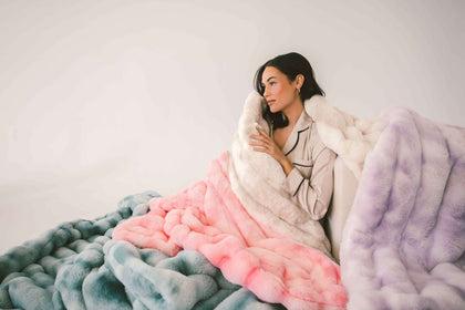 A woman wrapped in the soft Extreme Ultra Cloud weighted blankets, showcasing its cozy texture and soothing colors.