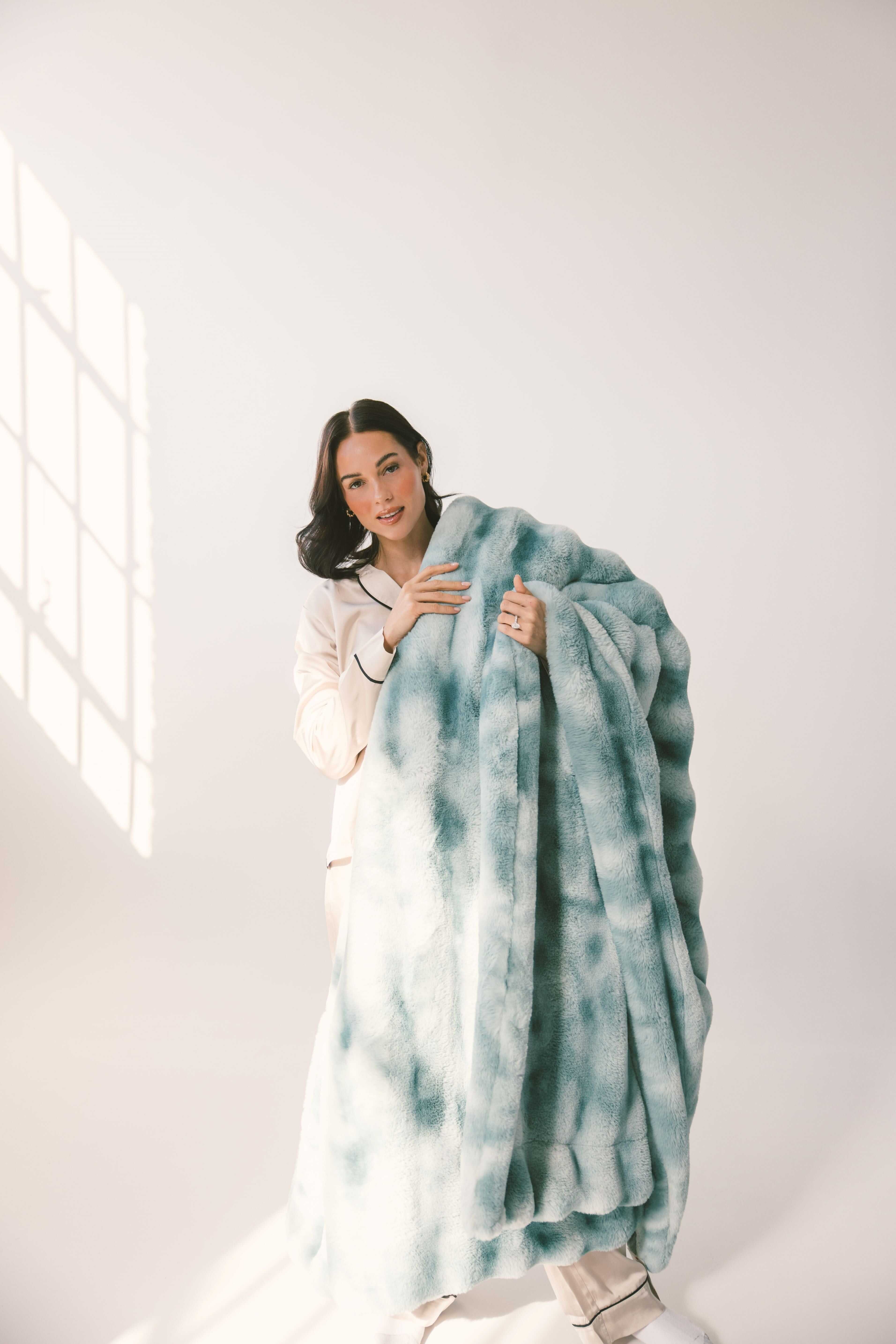 A woman holding the Extreme Ultra Cloud Smoke Blue weighted blanket, showcasing its plush texture and rich blue hue.
