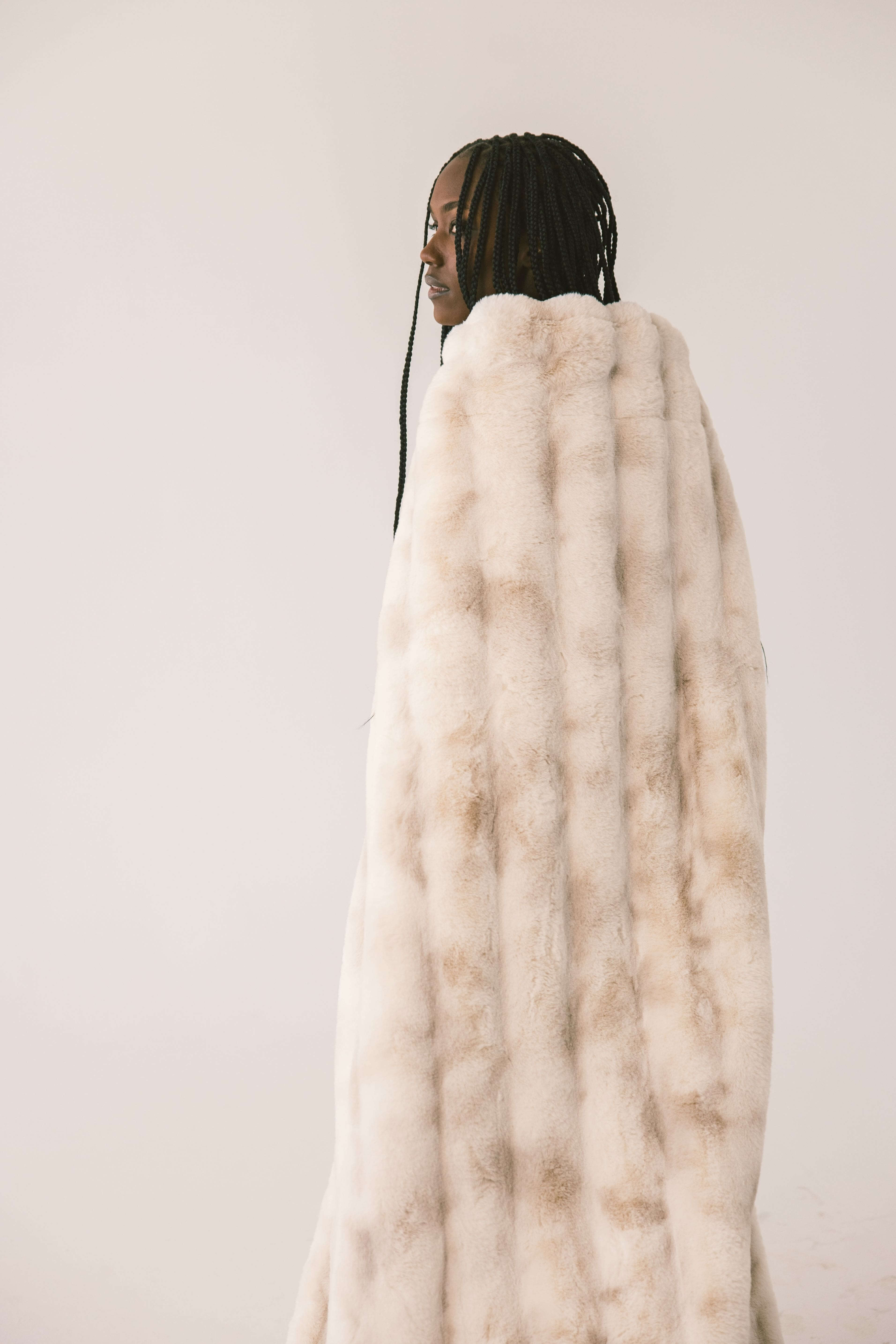 Model showcasing the Extreme Ultra Cloud Ancient Scroll Blanket with a soft tan hue and plush texture.