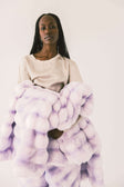 A model draped in the Extreme Ultra Cloud Lilac Breeze weighted blanket, showcasing its ultra-plush texture and soothing purple hue.