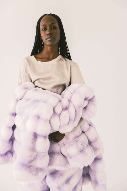 A model draped in the Extreme Ultra Cloud Lilac Breeze weighted blanket, showcasing its ultra-plush texture and soothing purple hue.
