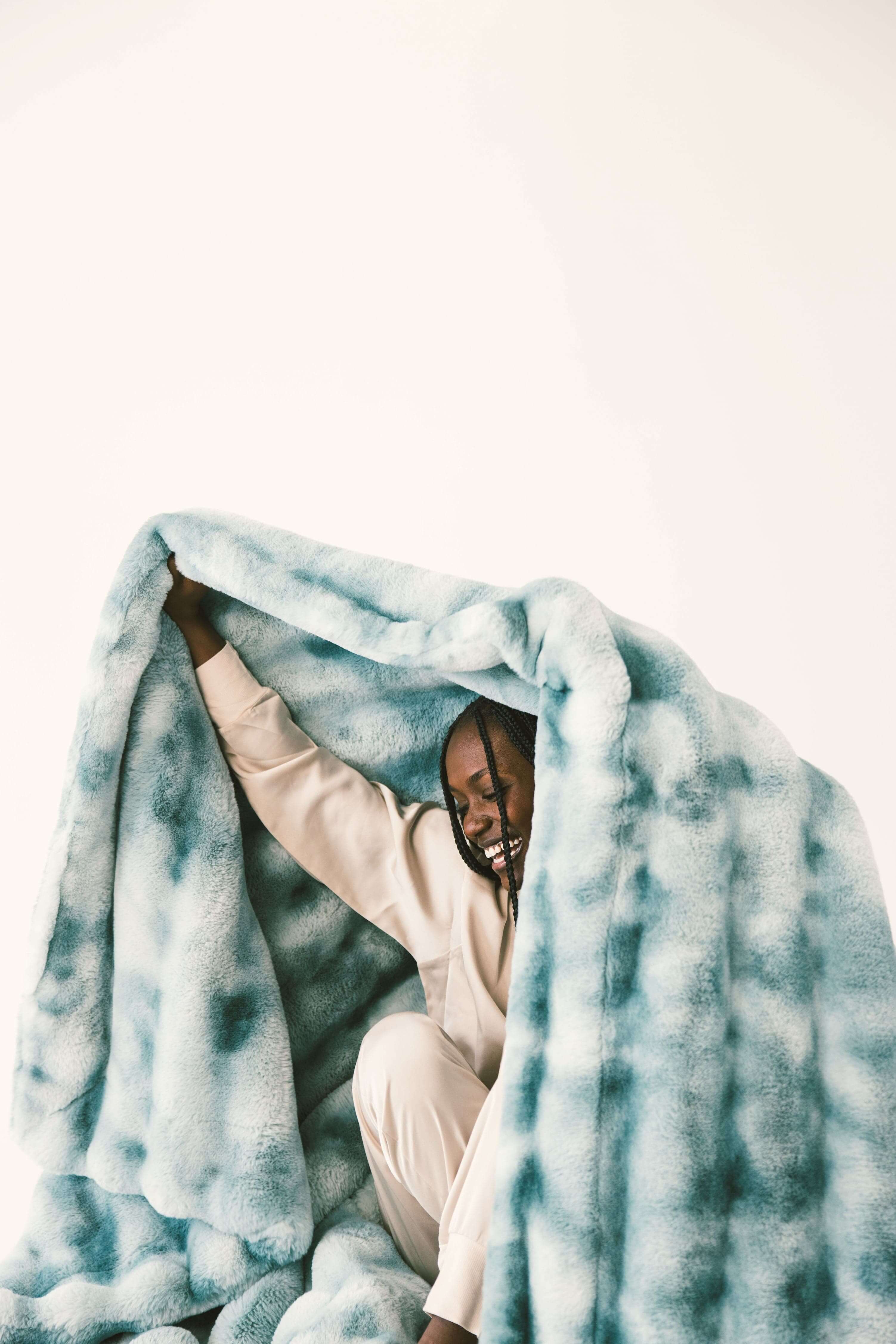 Person enjoying the cozy comfort of the Extreme Ultra Cloud Smoke Blue weighted blanket, showcasing its softness and luxury.