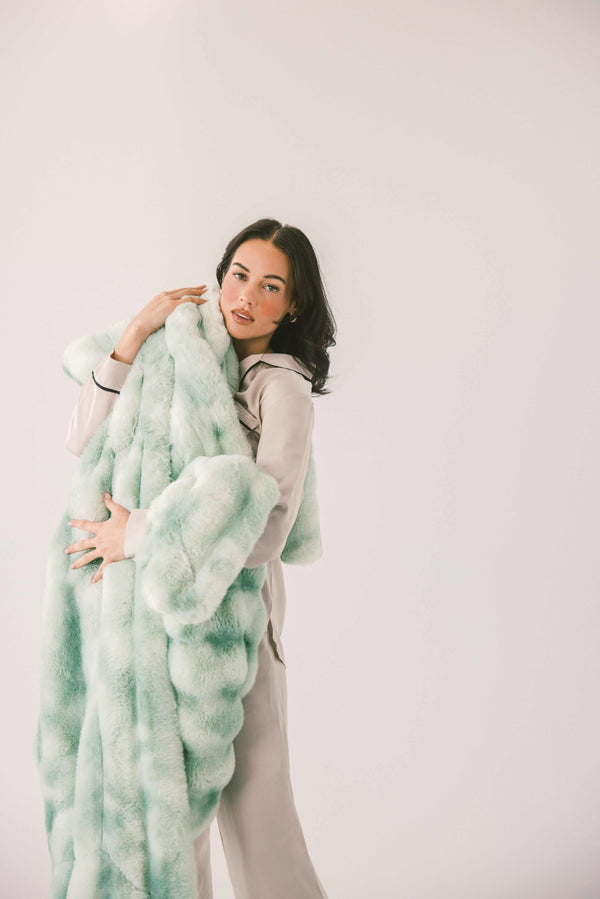 Woman holding the Extreme Ultra Cloud Malachite Green Blanket, showcasing its plush texture and cozy design.
